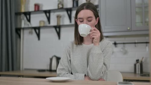 Woman Drinks Coffee in Kitchen with Natural Light