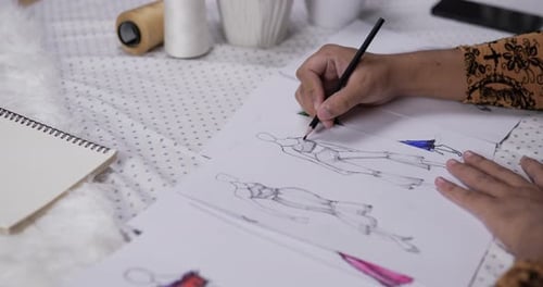 Nahaufnahme der Hand eines Modedesigners, der eine Skizze, Kleidung zeichnet