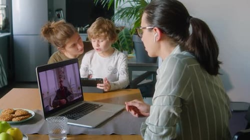 Frau, die zu Hause geschäftlich am Laptop telefoniert
