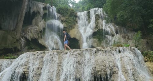 Man Walking Through Waterfall