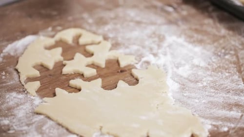 Adult Makes Cookies in Star and Snowflake Shapes