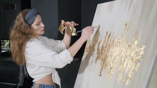 Junge Künstlerin, die Blattgold auf ihr Kunstwerk anwendet
