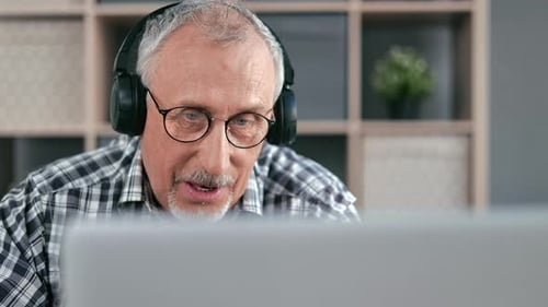 Senior Man with Headphones Using Computer