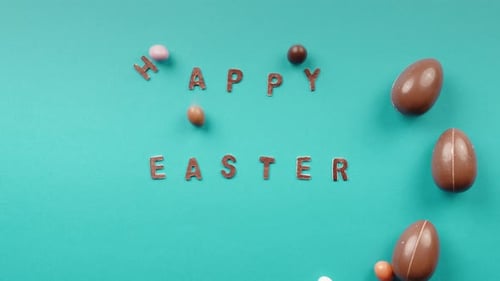 Easter Chocolate Eggs Rolling on a Yellow Background