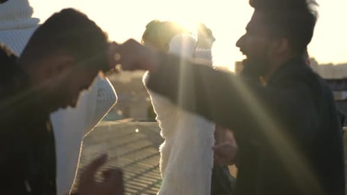 Group of Friends Gather on Rooftop at Sunset