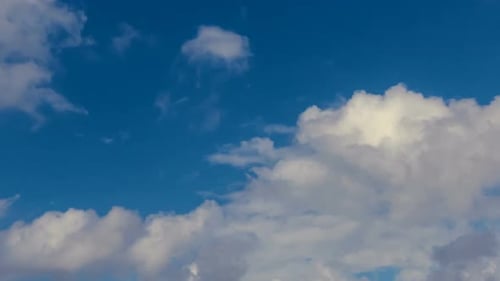 Fluffy White Clouds Above Ocean on Sunny Day
