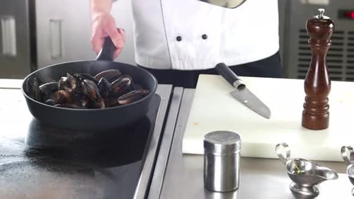 Chef Cooks Steaming Mussels in a Pan