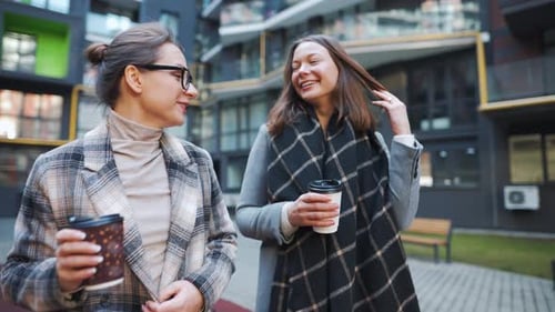 Two Friends Chat and Stroll Through Urban Courtyard