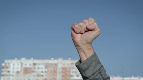 Man Raises Clenched Fist in Air