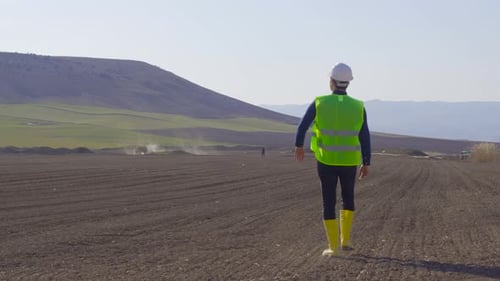 Engineer Inspecting Farming Fields on Sunny Day