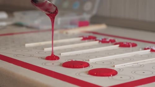 Making Lollipops Pouring Red Caramel on the Paper