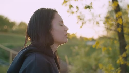 A Girl on a Cancer Run Puts on an Earphone and Listens to Music