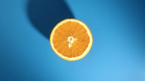 Top View Summer Orange Half Turning Fresh Dieting Natural Organic Dessert Piece Isolated on Blue