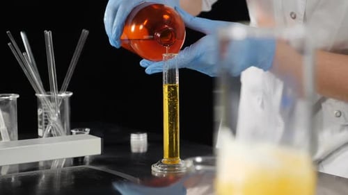 Kosmetikindustrie. Laborassistenten beim Mischen von Zutaten in Glasflaschen