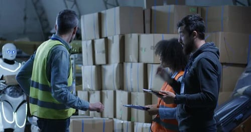 Warehouse Workers Consult with Robot Passing By