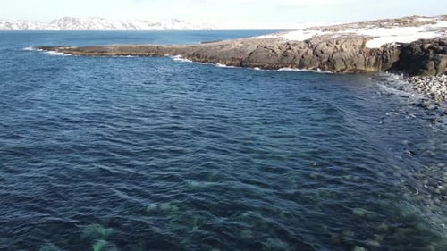 Winter Aerial Flight Top Over Waves Rolling on Artic Ocean Shore with Round Stones Ocean Waves at