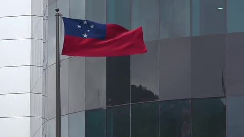 Samoa Flag Waving on Flagpole with Modern Building Background