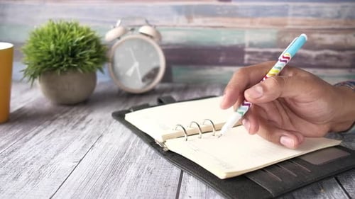 Close Up of Man Hand Writing on Notepad