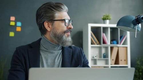 Handsome Mature Man Relaxing in Office Then Working with Laptop Computer Typing