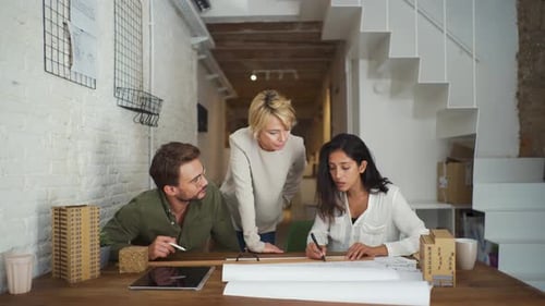Three architects working together at desk in an office
