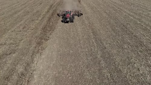 Tractor Cultivating Field at Spring