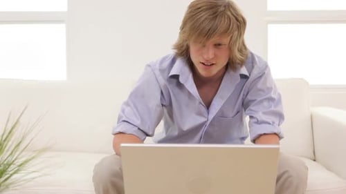 Young Adult Using Laptop and Talking on Phone