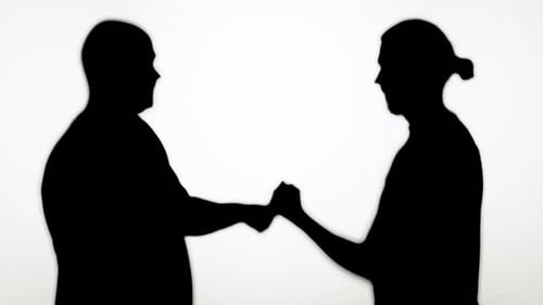Silhouette Figures in a Confrontation Fist Bump