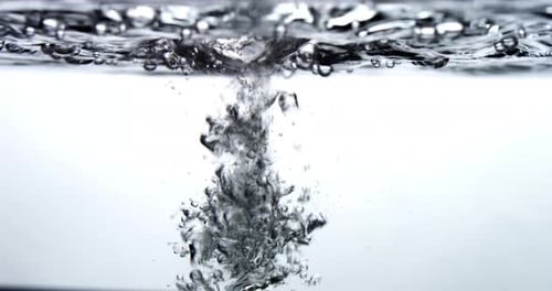 Wasser tropft in eine Wasseroberfläche - weißer Hintergrund