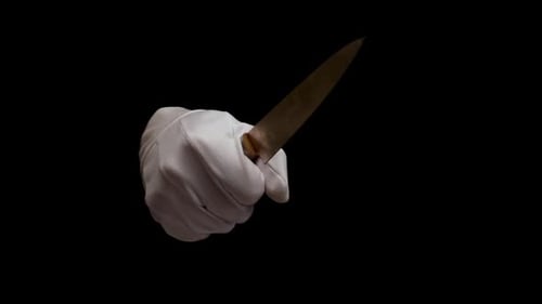 Male hand in white glove holding a knife isolated on black background