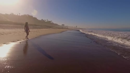 Woman Walking On The Beach