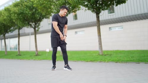Man Stretching Outdoors on Paved Path