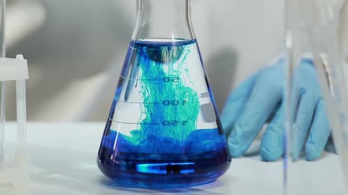 Un assistant de laboratoire fait des expériences de production de produits chimiques ménagers