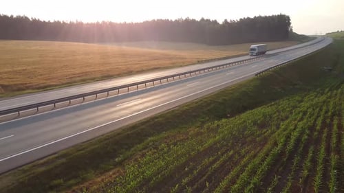 Semi Truck with Cargo drives along a wide highway through a scenic valley