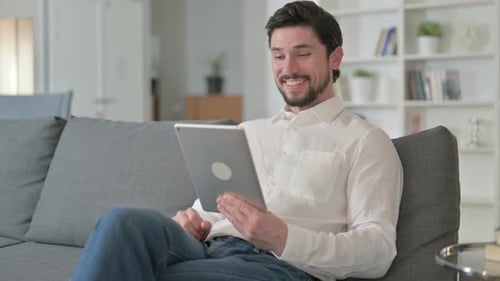 Man Video Chatting on Tablet at Home