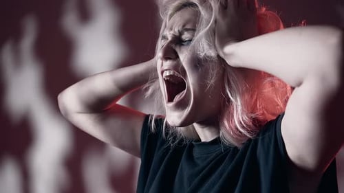 Woman Screaming in Pain with Hands on Head