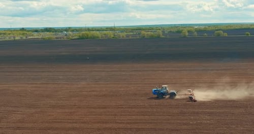 Tractor is Plowing Farm Field in Seeding Season View From Drone Prores