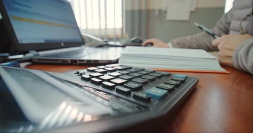 Close Up of Woman Hands Working on Laptop and Calculator, Counting Checks.