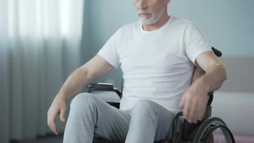 Older Man Sitting in Wheelchair Indoors