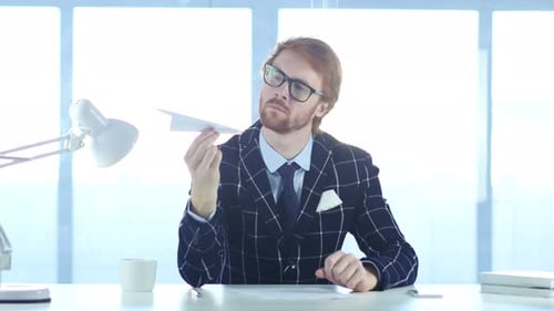 Man With Paper Airplane in Office
