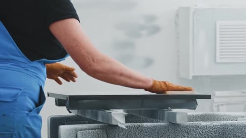 Worker Sands Surface with Hand Sanding Block