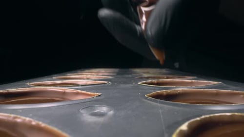 Chef Filling Molds with Melted Chocolate