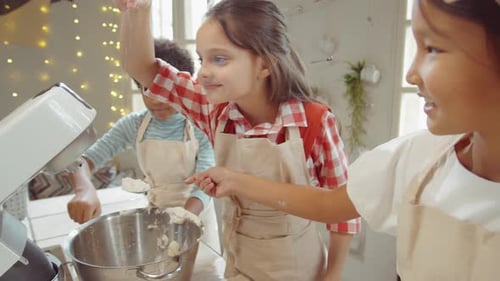 Kinder fügen Mehl in die Rührschüssel bei Cooking Masterclass