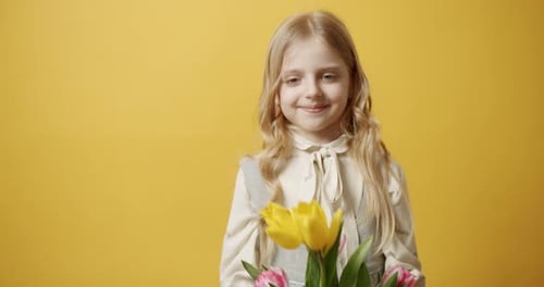 Smiling Girl Holding Colorful Tulips in Studio
