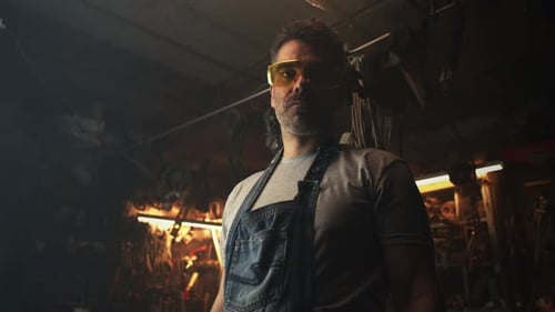 A Man in Garage Looking at Camera