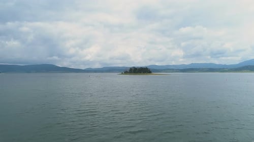 Lake Island with Green Trees Against Beautiful Storm Clouds