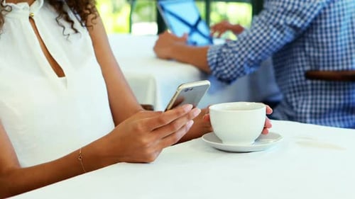 Woman Using Smartphone at Restaurant Table