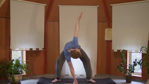 Young Adult Performs Yoga Poses and Stretches Indoors