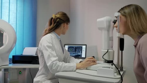 Der Augenarzt untersucht das Auge des Patienten und schaut dann in die Kamera