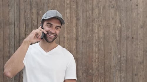 Young Man Chatting on Smartphone, Smiling