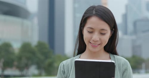 Woman Using Tablet in City Setting
